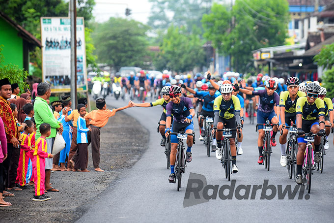 DISAMBUT MERIAH: Para pembalap Bluefire Ijen KOM Chalenge 2022 melintas di jalan raya Desa Yosomulyo, Kecamatan Gambiran Sabtu (24/9). (Ramada Kusuma/Radar Banyuwangi)