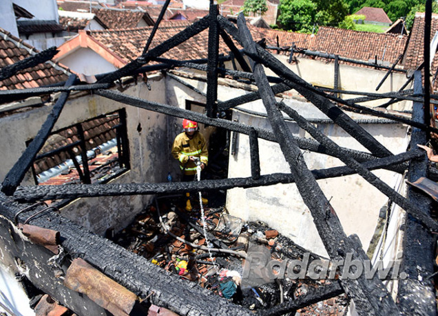 BERJIBAKU: Petugas Dinas Damkar dan Penyelamatan berhasil memadamkan api yang membakar rumah di Kelurahan Temenggungan, Kecamatan Banyuwangi, Kamis (8/9). (Ramada Kusuma/Radar Banyuwangi)