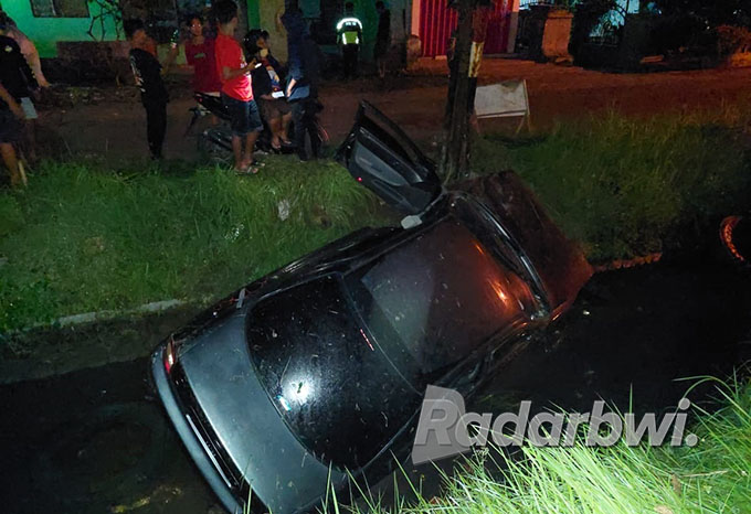 JADI TONTONAN: Sejumlah warga melihat dari dekat kondisi mobil yang masuk parit di wilayah Desa Yosomulyo Kecamatan Gambiran, Minggu (25/9) dini hari. (Polsek Gambiran for Radar Banyuwangi)