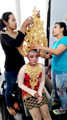 KETIBAN BERKAH: Istiqomah, 32 warga Dusun Purwosari, Desa Benculuk, Kecamatan Cluring, merias salah satu peserta karnaval kemarin (31/8). (Deddy Jumhardiyanto/RadarBanyuwangi.id)