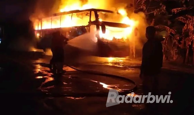 MENEGANGKAN: Petugas pemadam kebakaran berusaha memadamkan si jago merah yang melahap Bus malam di Jalan Raya Pasir Putih, Desa Mlandingan Wetan, Kecamatan Bungatan, Kamis (1/8) malam. (Humaidi/Radar Situbondo)