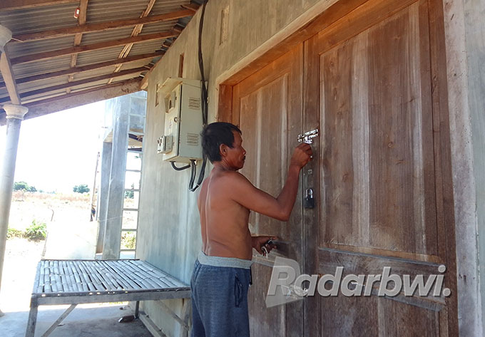 PENJAGA SUMUR BOR: Miswiyanto, warga Desa Sidowangi, Kecamatan Wongsorejo, membuka gerbang sumur bor untuk mengalirkan air ke sawah warga, Minggu (25/9). (Humaidi/Radar Banyuwangi)