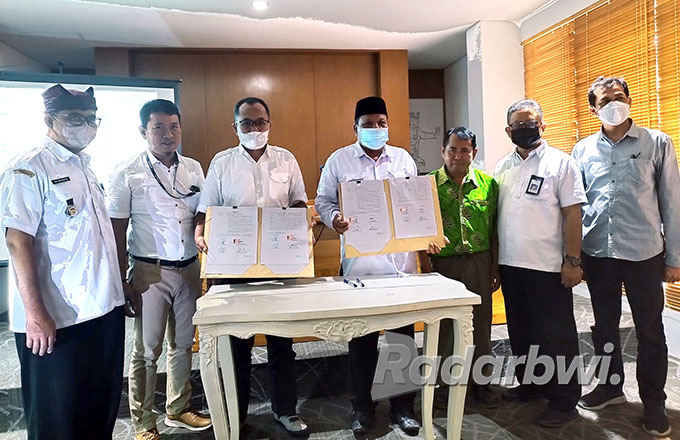SINERGI: ADM Bumisari Sudjarwo (tiga dari kiri) dan Kades Kluncing, Kecamatan Licin, Sumawi (empat dari kanan) sepakat menjalin kerja sama di kantor Pemkab Banyuwangi, Rabu (31/8). (Bagus Rio/Radar Banyuwangi)