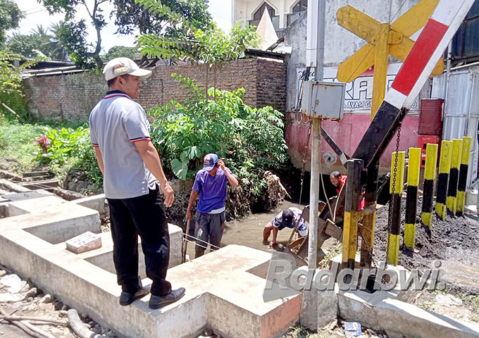 KERUK SEDIMEN: Warga Desa Genteng Wetan, Kecamatan Kalibaru turun ke selokan untuk memberishkan sampah dan sedimen, Kamis (15/9). (Ismanto for Radar Genteng)