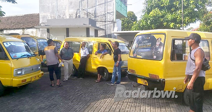 MAKIN TERPURUK: Sejumlah sopir angkutan kota  beristirahat menunggu siswa yang berkunjung ke kantor Grha Pena Banyuwangi, Jumat (16/9). (Humaidi/Radar Banyuwangi)