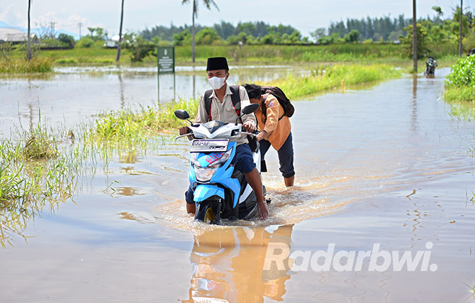 TERBIASA: Genangan air cukup luas menutup areal jalan dan persawahan di Lingkungan Rowo, Kelurahan Pakis, Kecamatan Banyuwangi, tahun lalu. (Ramada Kusuma/Radar Banyuwangi)