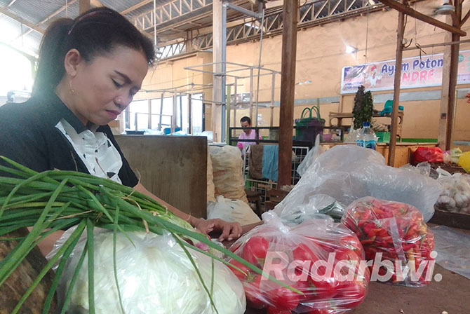 BERESKAN BARANG: Riskiyah pedagang bumbu di Pasar Panji menjumlah hasil penjualan dagangannya sebelum meninggalkan pasar, Senin (10/10). (Humaidi/Radar Situbondo)