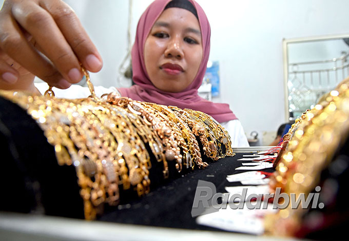 BERKILAU: Karyawati salah satu toko emas di Pasar Banyuwangi merapikan perhiasan yang dipajang di etalase, Selasa (4/10).
