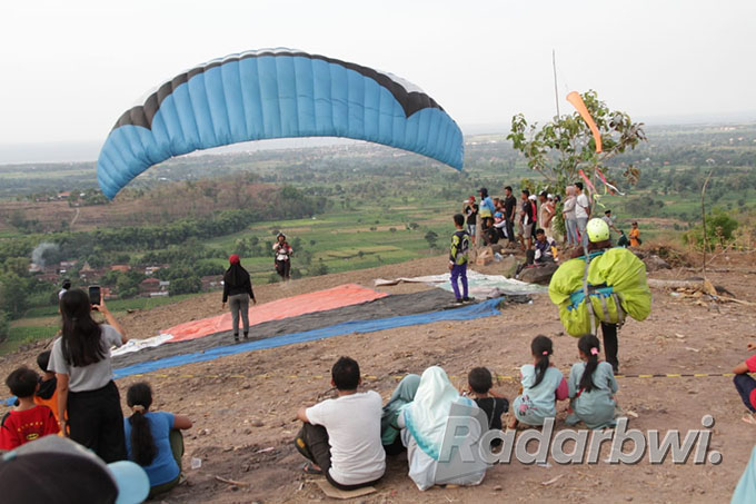 PERDANA: Sejumlah warga mendatangi titik lokasi yang digunakan untuk olahraga paralayang, di Desa Curah Suri, Kecamatan Jatibanteng, Kamis (29/9). (Iwan Feriyanto/Radar Situbondon)