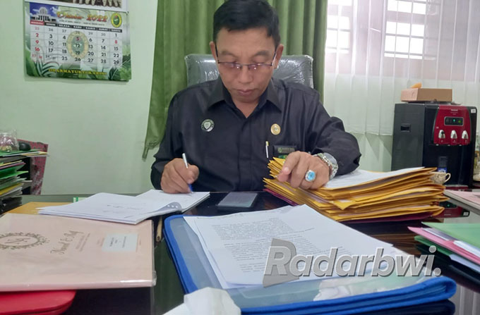 SIBUK : Panitera Sekretaris Subandi sedang menandatangani perkara perceraian di Kantor Pengadilan Agama, Selasa (4/10). (Ayu Lestari/Radar Banyuwangi)
