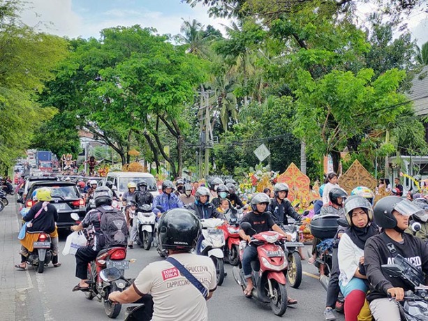 ANTRE: Kendaraan dari dua arah harus berjubel bersama dengan rombongn kirab pawai jodang di Jalan Raya depan Puskesmas Gitik, Kecamatan Rogojampi, kemarin (16/10) (Deddy Jumhardiyanto/RadarBanyuwangi.id)