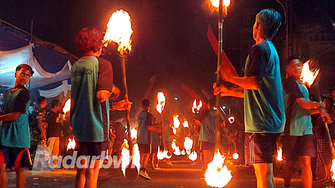 TRADISI: Anak-anak muda Desa Tambong beradu kreativitas pencak obor pada kirab jodang, Sabtu malam (22/10).(Dedy Jumhardiyanto/Radar Banyuwangi)