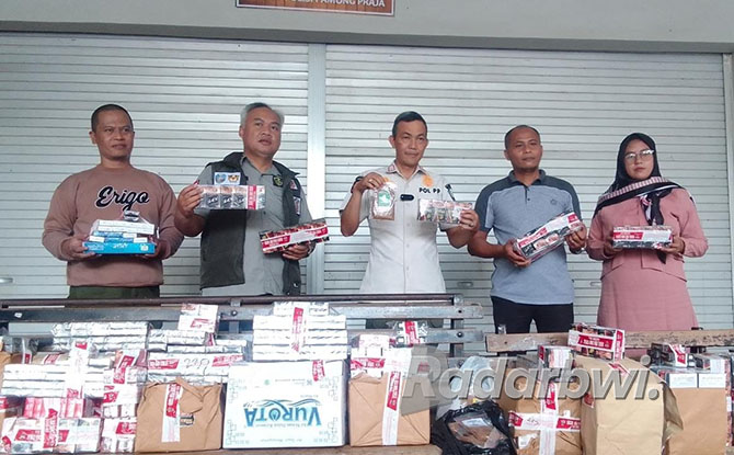 BARANG ILEGAL: Kepala Seksi Penindakan dan Penyidikan Bea Cukai Jember, Widodo Wiji Mulyono (pakai rompi) dan Kepala Satpol PP Kabupaten Situbondo, Buchari (baju putih) menunjukkan rokok ilegal, di Kantor Satpol PP Kabupaten Situbondo, Kamis (27/10) lalu.