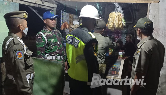 SIDAK WARUNG: Anggota Satpol PP Situbondo melakukan pengecekan minuman keras (miras) di seluruh warung remang-remang di Kecamatan Besuki, Rabu (26/10) dini hari. (Humaidi/Radar Situbondo)