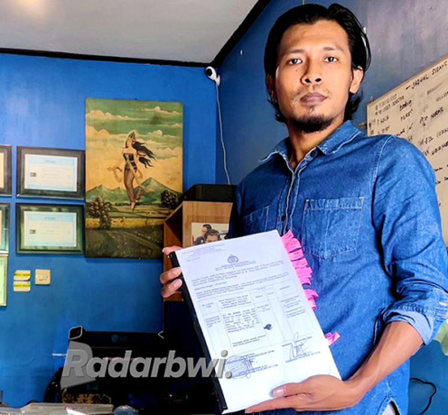 TUNJUKKAN BAP: Aris Pianto menunjukkan BAP kliennya yang dianggap banyak keganjilan, Kamis (27/10). (Bagus Rio/Radar Banyuwangi)