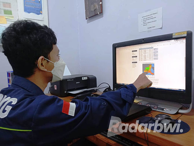 RAMALAN CUACA: Anjar Trionohadi menunjukkan prakiraan cuaca melalui layar monitor di kantor BMKG Banyuwangi, Selasa (11/10). (Bagus Rio/Radar Banyuwangi)