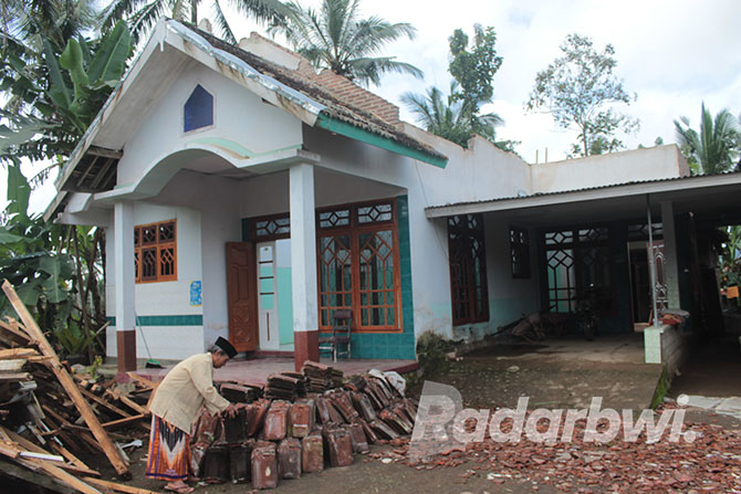 HANCUR: Imam Masduki memilih genting rumah yang bisa dipakai lagi saat perbaikan, Senin (10/10). (Salis Ali/Radar Genteng)