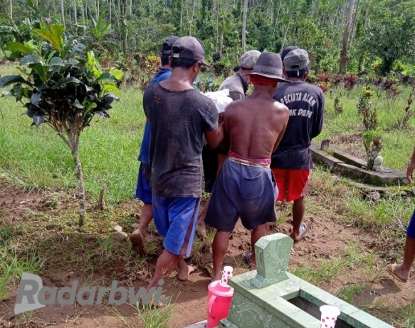 DIKUBUR LAGI : Warga menggotong jenazah manusia yang hanyut setelah makamnya diterjang banjir, Minggu (20/12)
