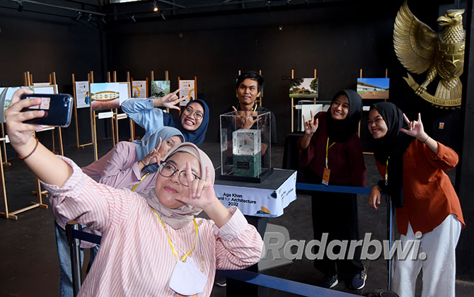 POPULER: Pengunjung berfoto bersama dengan Piala Aga Khan Award for Architecture di Gedung Juang 45 Banyuwangi kemarin. (RAMADA KUSUMA/RABA)