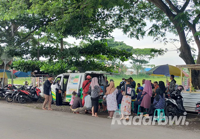 RAMAI: Masyarakat antre membayar pajak kendaraan bermotor di mobil layanan Samsat yang parkir di tepi Lapangan Lugjak, Desa Pengatigan, Kecamatan Rogojampi, Banyuwangi, Jumat lalu (18/11). (DEDY JUMHARDIYANTO/RABA)