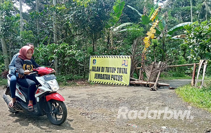 DITUTUP: Papan larangan masuk karena jembatan putus terpasang di Dusun Tegalrejo, Desa Bayu, Kecamatan Songgon, Senin (21/11). (LUGAS RUMPAKAADI/JPRG)