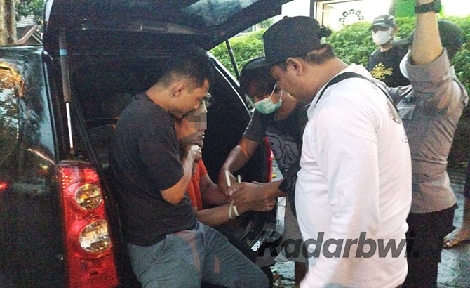 PELAKU PENUSUKAN: Ivan digelandang anggota Resmob menuju lokasi penusukan di Kelurahan Sobo, Banyuwangi, Jumat (18/11). (BAGUS RIO/RABA)