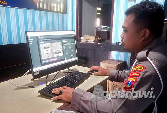 BIDIK PELANGGAR: Anggota Unit Gakkum Satlantas Polresta Banyuwangi memantau pelanggaran lalu lintas &nbsp;melalui layar monitor sistem ETLE di jalanan kota Banyuwangi, Minggu (13/11). (BAGUS RIO/RABA)