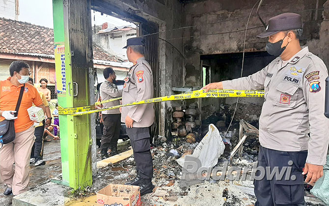IDENTIFIKASI: Anggota Polresta Banyuwangi melakukan olah TKP di toko kelontong yang terbakar  di Jalan Progo, Kelurahan Singonegaran, Minggu (27/11). (BAGUS RIO/RABA)