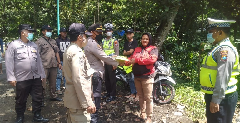 BANTU: Plt Kapolske Kalibaru Iptu Yaman Adinata membagikan rompi pada relawan jalur Gumitir, Desa Kalibaru Manis, Kecamatan Kalibaru, Selasa (1/11).