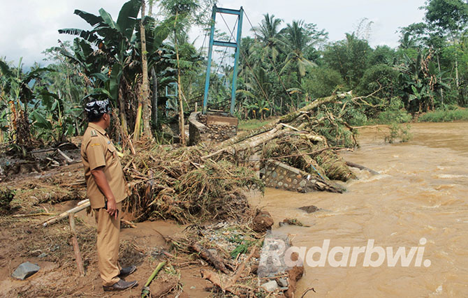 HANCUR: Kepala Desa Kandangan Riyono melihat jembatan yang menghubungkan Dusun Sumberdadi dan Dusun Sumbergandeng, Desa Kandangan yang putus. (SALIS ALI/JPRG)