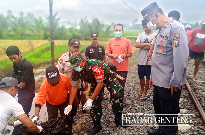EVAKUASI: Anggota Polsek Singojuruh dibantu warga mengevakuasi mayat Sugihart yang tertemper KA Wijaya Kusuma, Minggu (27/11). (POLSEK SINGOJURUH UNTUK JPRG)