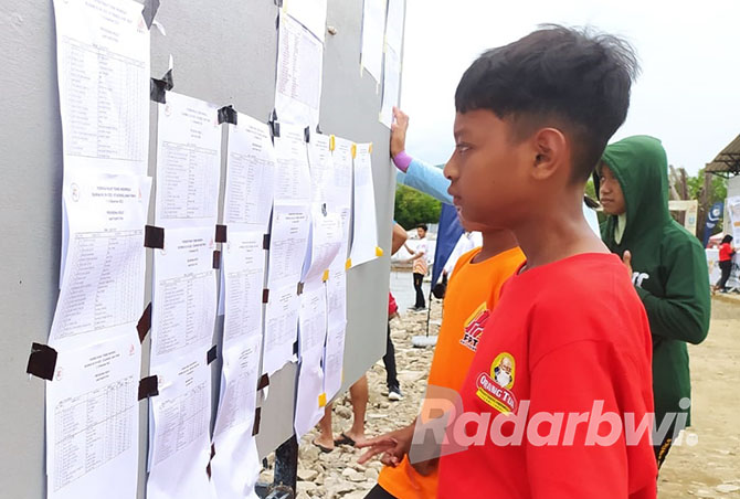 Anak-anak mengerumuni papan pengumuman perolehan medali Kejurnas Panjat Tebing di Pasir Putih, Bungatan, Situbondo. (IWAN FERIYANTO/JPRS)