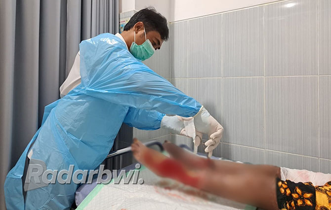 SABAR: Petugas Poli Bedah RSUD Genteng merawat luka pasien setelah Skin Graft. (SRY INDAYANI UNTUK JPRG)