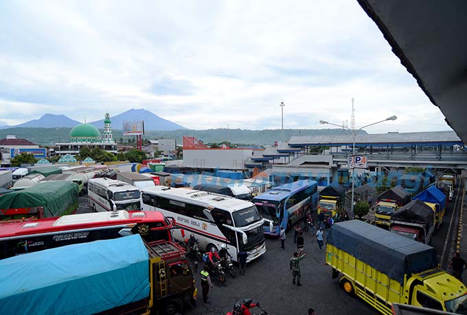 Sejumlah Kendaraan dan bus  sedang mengantri masuk kapal di halaman parkir pelabuhan Asdp Ketapang Banyuwangi. lonjkan penumpang di pelabuhan ketapang mulai terlihat menjelang liburan Natal Tahun Baru