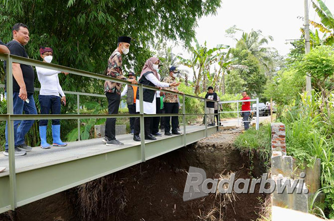 BUAH GOTONG ROYONG: Bupati Ipuk Fiestiandani didampingi Kadis PU Pengairan Guntur Priambodo dan Plt Kadis PU-CKPP Danang Hartanto meninjau jembatan darurat di Desa Kalibaru Wetan, Jumat (2/12). (DINI UNTUK RABA)