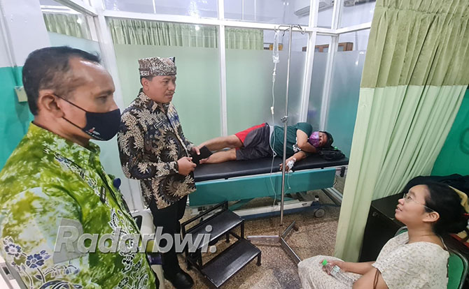 DIINFUS: Plt Kadinkes Amir Hidayat melihat kondisi peserta gathering yang menjalani perawatan di RSI Yasmin, Senin (12/12). (Fredy Rizki/Radar Banyuwangi)