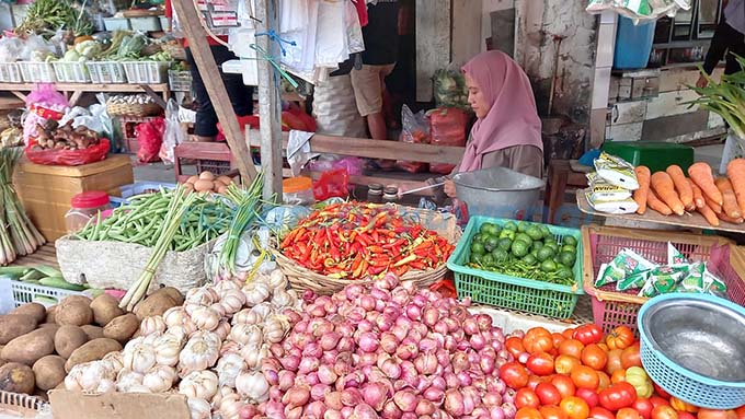 MEROKET : Penjual sayur di Pasar Banyuwangi tengah menunggu pembeli kemarin (20/12). Harga sembako dan sejumlah komoditas lainnya naik menjelang Nataru.  (Ayu Lestari/RadarBanyuwangi.id)