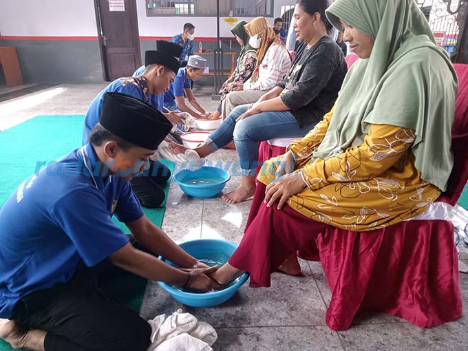 MOMEN HARI IBU: Sejumlah napi yang tinggal di Lapas Banyuwangi membasuh kaki ibunya saat dikunjungi keluarganya kemarin (22/12).  (Bagus Rio/RadarBanyuwangi.id)