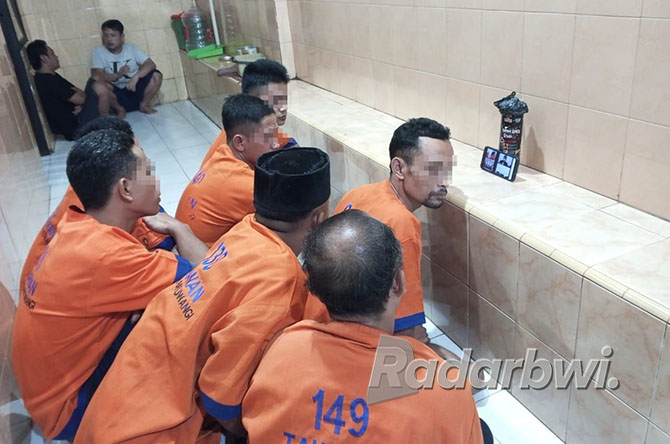 DUDUK DI LANTAI: Tujuh terdakwa penebangan pohon milik Perkebunan Bumisari menjalani sidang di ruang tahanan Polresta Banyuwangi, Minggu lalu. (DOK.RABA)