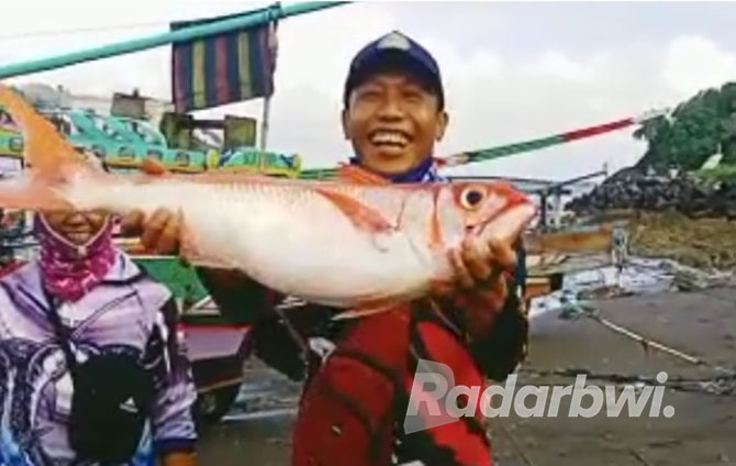 STRIKE: Warga menunjukkan ikan hasil tangkapan di Selat Bali. (GARETA WARDANI/RABA)