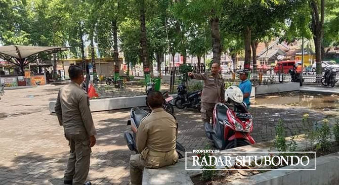 BUBARKAN PARKIR LIAR: Anggota Satpol PP menertibkan sepeda motor yang parkir sembarangan di Pujasera Alun-Alun Kota Situbondo, Minggu (29/1).