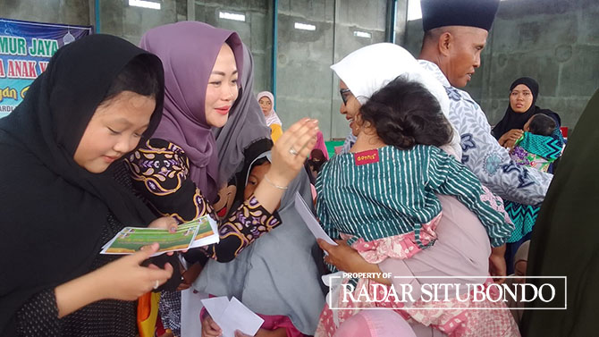 MOMEN BAHAGIA:  Direktur Lintang Timur Jaya, Ahmad Mujiono didampingi istri dan kedua anaknya, menyantuni anak yatim piatu di kantor CV Lintang Timur, Desa Awar-awar, Kecamatan Asembagus, Sabtu lalu (31/12/22). (Humaidi/Radar Situbondo)