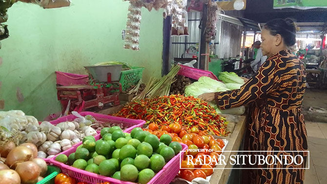 MENUNGGU PEMBELI: Ami, pedagang di Pasar Mimbaan Baru tengah merapikan dagangannya sembari menunggu pembeli, Selasa (3/1/23). (Humaidi/Radar Situbondo)