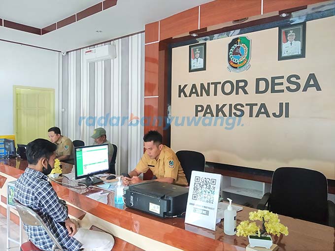 PELAYANAN: Petugas membantu proses administrasi warga di kantor Desa Pakistaji, Senin (9/2). (Gareta Wardani/RadarBanyuwangi.id)
