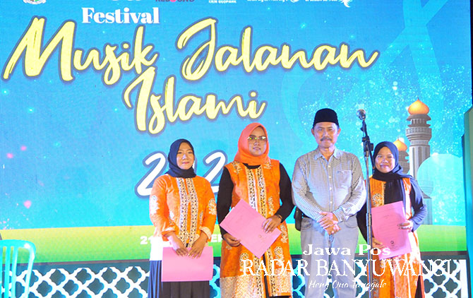 MALAM BAHAGIA: Camat Banyuwangi Danisworo saat memberikan penghargaan Kader PKK, Kader Posyandu, Kader Kesehatan, Petugas kebersihan lingkungan di acara Festival Musik Jalanan Islami di RT 04/04 Krajan Kertosari, Sabtu (7/1). (Toha/Radar Banyuwangi)