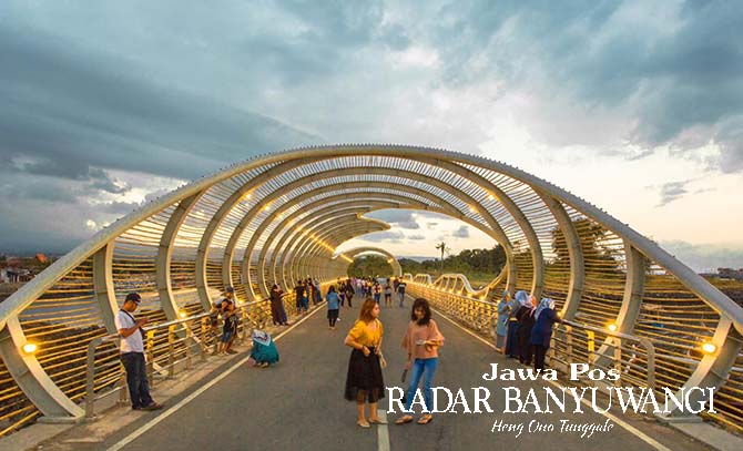 SPOT FAVORIT: Sejumlah wisatawan menikmati suasana di jembatan spiral kawasan Pantai Marina Boom Banyuwangi. (Dini untuk Radar Banyuwangi)