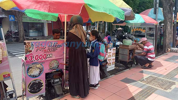 BERDERET: Para pedagang kaki lima menjual aneka jajanan tak jauh dari sekolah kemarin (25/1). (Ayu Lestari/RadarBanyuwangi.id)