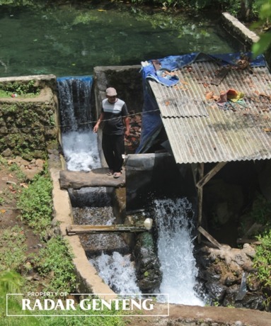 BERMANFAAT: Tugirin mengecek turbin penghasil listrik di bawah aliran Air Terjun Legomoro, Dusun Sumbermulyo, Desa Margomulyo, Kecamatan Glenmore, Minggu (15/1). (Foto: Salis Ali/JPRG)