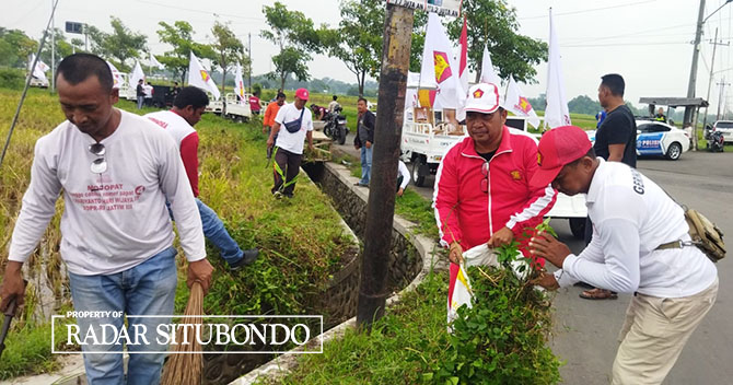 GOTONG ROYONG: Wakil Ketua DPRD, Jainur Ridho membersihkan rumput di pinggir jalan, Desa Panji Kidul, Kecamatan Panji, Minggu (5/2). (Iwan Feriyanto/Radar Situbondo)