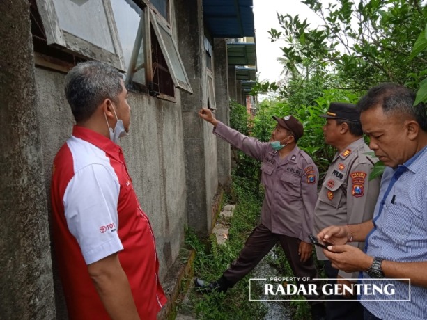 DIBOBOL: Anggota Polsek Gambiran memeriksa jendela ruang kelas praktik SMK Muhammadiyah 9 Gambiran yang dirusak maling, Kamis (9/2). (Foto: Rohman untuk JPRG)